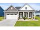 Charming single-story home featuring a manicured lawn, covered porch, and a two-car garage at 314 Bumble Circle, Murrells Inlet, SC 29576