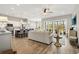 Open-concept living area with wood floors, a spacious sofa, and views of the modern kitchen and outdoor patio at 314 Bumble Circle, Murrells Inlet, SC 29576