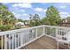 Scenic balcony view overlooking the water, surrounded by lush greenery and charming neighborhood homes at 327 A Lakeside Dr., Surfside Beach, SC 29575