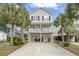 Charming two-story beach house on stilts with palm trees and a well-maintained yard at 327 A Lakeside Dr., Surfside Beach, SC 29575