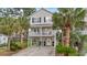 Charming two-story beach house on stilts with palm trees and a well-maintained yard at 327 A Lakeside Dr., Surfside Beach, SC 29575