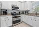 Bright kitchen featuring white cabinets, stainless steel appliances, and granite countertops at 327 A Lakeside Dr., Surfside Beach, SC 29575