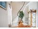 Elegant foyer showcasing a curved staircase, hardwood floors, and a decorative display cabinet at 328 Waterside Dr., Myrtle Beach, SC 29577