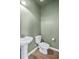 Powder room featuring a pedestal sink, toilet, and wood-look flooring at 3547 Ladybank Loop, Myrtle Beach, SC 29577