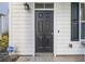 A close-up of a black front door with modern hardware, located on a white home exterior at 3547 Ladybank Loop, Myrtle Beach, SC 29577