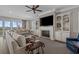 Comfortable living room with a fireplace, built-in shelving, a ceiling fan, and ample natural light at 397 St. Julian Ln., Myrtle Beach, SC 29579
