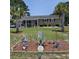 Charming brick home with well-maintained lawn, mature palm trees, and unique garden decor at 4083 Sand Trap Ave., Little River, SC 29566