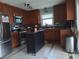 Well-equipped kitchen with stainless steel appliances, wooden cabinets, and a movable kitchen island at 4083 Sand Trap Ave., Little River, SC 29566