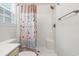 Clean bathroom featuring a shower with colorful patterned curtain, toilet, and window with blinds at 4331 Grande Harbour Blvd., Little River, SC 29566