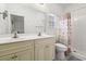 Bright bathroom with double sinks, large mirror, a toilet, and a shower with a beige seashell-themed curtain at 4331 Grande Harbour Blvd., Little River, SC 29566