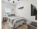 Well-lit bedroom featuring a striped bed, wood-look flooring, and mounted flatscreen TV for comfortable relaxation at 4331 Grande Harbour Blvd., Little River, SC 29566