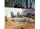 Backyard seating area with chairs, benches, a fire pit, and a white fence for outdoor gatherings and relaxation at 4447 River Rd., Little River, SC 29566