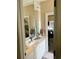 Bathroom with a mirror over the sink and a view into another room; neutral color palette and tile flooring at 4447 River Rd., Little River, SC 29566