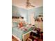 Bright bedroom with blue walls, ceiling fan, and decor; featuring a bed, dresser, and plenty of natural light at 4447 River Rd., Little River, SC 29566