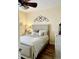 Comfortable bedroom with hardwood floors, ceiling fan and natural light, complete with a bed, nightstand, and decor at 4447 River Rd., Little River, SC 29566