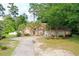 Charming brick home with mature landscaping, long driveway, and a well-manicured front yard at 4447 River Rd., Little River, SC 29566