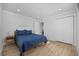 Bright bedroom featuring wood floors, a comfy blue quilted bed, closet and a door at 4501 N Ocean Blvd., North Myrtle Beach, SC 29582