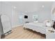 Sunlit bedroom featuring white decor, light wood flooring, and a mirror at 4501 N Ocean Blvd., North Myrtle Beach, SC 29582