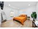 A well-lit bedroom with wood floors, a full-length mirror, art and a comfy bed at 4501 N Ocean Blvd., North Myrtle Beach, SC 29582