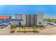 Aerial view of a beachfront condo complex with lush landscaping, ample parking, and a glimpse of the ocean at 4525 S Ocean Blvd. # 406, North Myrtle Beach, SC 29582