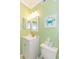 This lovely bathroom has a toilet, a vanity with sink and mirror and lime green painted walls at 4525 S Ocean Blvd. # 406, North Myrtle Beach, SC 29582