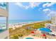High angle view of a crowded beach and the ocean from a balcony overlooking a pool at 4525 S Ocean Blvd. # 406, North Myrtle Beach, SC 29582