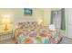 Comfortable bedroom with colorful, tropical bedding, side tables, and a view from the window at 4525 S Ocean Blvd. # 406, North Myrtle Beach, SC 29582