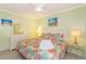 Cozy bedroom featuring a tropical themed bedspread, a dresser with mirror, and coastal art at 4525 S Ocean Blvd. # 406, North Myrtle Beach, SC 29582