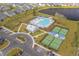 Aerial view of community pool and tennis courts, with houses and a pond in the background at 4555 Weekly Dr, Myrtle Beach, SC 29579