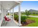 Inviting front porch with classic white columns, a seating area, and manicured landscaping at 4555 Weekly Dr, Myrtle Beach, SC 29579
