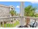 Nice balcony with furniture and view of the buildings, grass and palm trees at 4705 Wild Iris Dr. # 201, Myrtle Beach, SC 29577