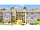 A charming condo complex featuring balconies, lush landscaping, and a well-maintained exterior at 4705 Wild Iris Dr. # 201, Myrtle Beach, SC 29577
