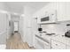 A bright kitchen with white cabinetry, appliances, and wood grain floors at 4705 Wild Iris Dr. # 201, Myrtle Beach, SC 29577