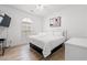 Airy main bedroom features a white queen bed, dresser, and large window at 4705 Wild Iris Dr. # 201, Myrtle Beach, SC 29577