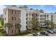 Well-maintained condo building with lush landscaping, parking, and multiple balconies at 4878 Luster Leaf Circle # 102, Myrtle Beach, SC 29577