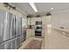 Well-lit kitchen features stainless steel appliances, cream-colored cabinets, and a leopard print rug at 4878 Luster Leaf Circle # 102, Myrtle Beach, SC 29577
