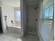 Modern bathroom features marble floors, separate soaking tub, and a tiled shower with black fixtures at 493 Emerson Dr., Myrtle Beach, SC 29579