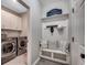Mud room with a bench, coat hooks, storage shelves, and adjacent laundry machines at 5013 Sassari St., Myrtle Beach, SC 29579