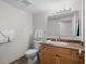 Clean bathroom with tile floors, modern toilet, large mirror, and oak colored vanity at 5310 N Ocean Blvd. # Ph 6 1506, Myrtle Beach, SC 29577