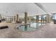 Indoor pool area with jacuzzi and large windows offering exterior views, inviting relaxation and recreation at 5310 N Ocean Blvd. # Ph 6 1506, Myrtle Beach, SC 29577