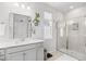 Well-lit bathroom with a modern vanity, glass-enclosed shower, and tiled walls at 560 Pier Ct., Longs, SC 29568