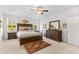 Bright bedroom with a decorative rug, ceiling fan, and a large, wood-framed bed with lake views at 560 Pier Ct., Longs, SC 29568