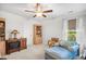 Bright bedroom with a blue chaise lounge, bookcase, ceiling fan, and lake views at 560 Pier Ct., Longs, SC 29568