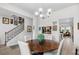 Charming dining area with a wooden table, white chairs, and easy access to the living room and stairway at 560 Pier Ct., Longs, SC 29568