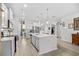 Contemporary kitchen boasts white cabinets, an expansive island, stainless appliances, and modern pendant lighting at 560 Pier Ct., Longs, SC 29568