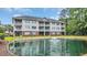 Multi-story condo building with balconies overlooking a pond with a fountain and manicured landscaping at 5825 Catalina Dr. # 523, North Myrtle Beach, SC 29582