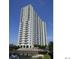 View of a tall condo building with a lake in front and blue sky at 5905 S Kings Highway # 1106, Myrtle Beach, SC 29575