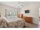 Bright bedroom with large window, wood grain flooring and matching wood furniture at 6000 Windsor Green Way # 104, Myrtle Beach, SC 29579