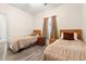 Bright bedroom features two twin beds, wood laminate flooring, and neutral-toned walls at 6000 Windsor Green Way # 104, Myrtle Beach, SC 29579
