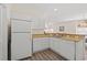 Efficient kitchen featuring white appliances, sleek counters, and wood grain vinyl flooring at 6000 Windsor Green Way # 104, Myrtle Beach, SC 29579